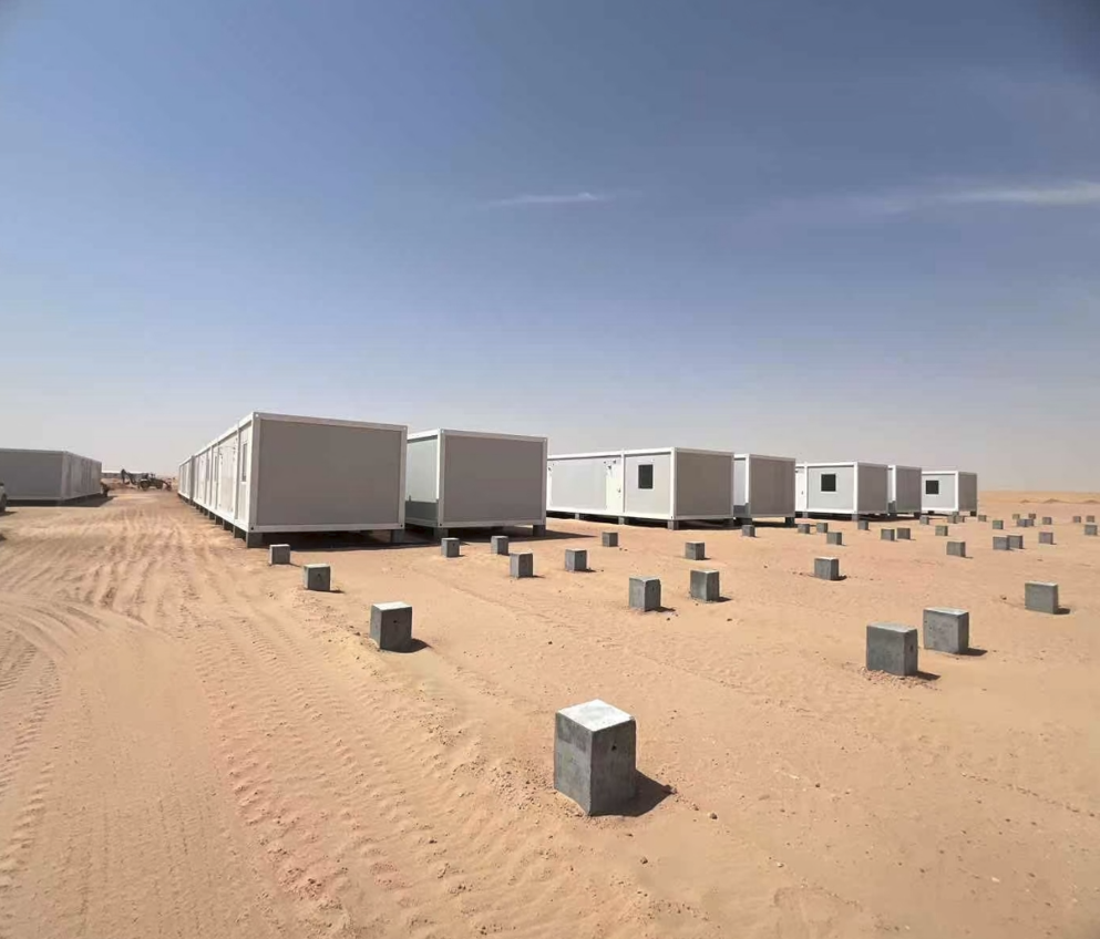 Container house camp project with modular units installed on desert site foundations
