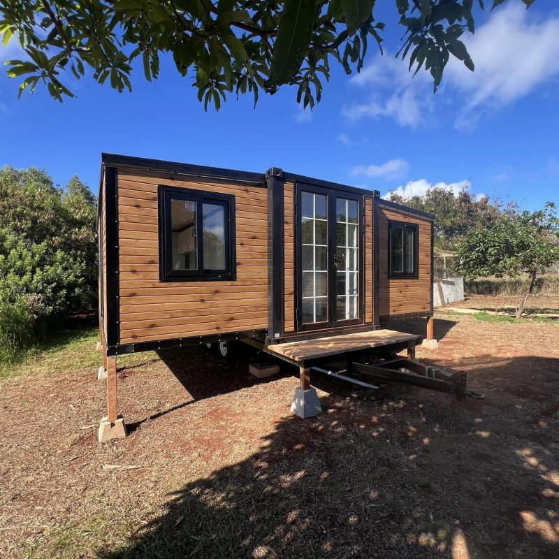 Side view of an expandable container house with wood-finish exterior